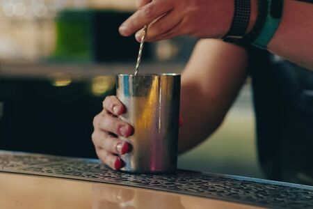 a Bartender pouring cocktail at bar counterの写真素材
