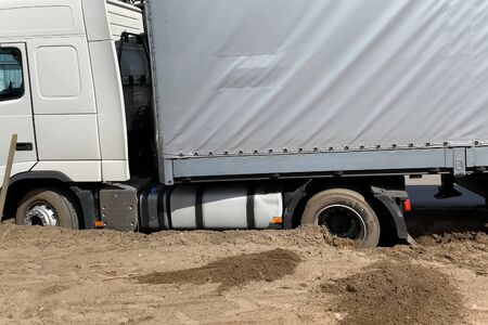 A truck stuck in the sand on the side of the road.の写真素材