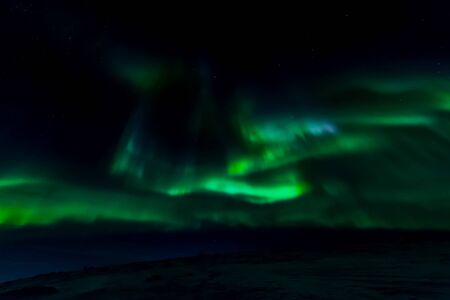Aurora borealis in the night northern sky. Ionization of air particles in the upper atmosphere.の写真素材