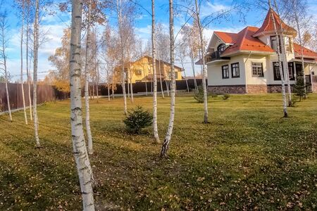 New house with a plot planted with birch trees. Beautiful home ownershipの写真素材