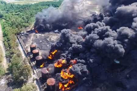 Oil storage fire. The tank farm is burning, black smoke is the combustion of hydrocarbons.の写真素材