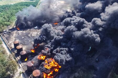 Oil storage fire. The tank farm is burning, black smoke is the combustion of hydrocarbons.の写真素材