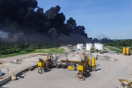 Oil storage fire. The tank farm is burning, black smoke is the combustion of hydrocarbons.の写真素材