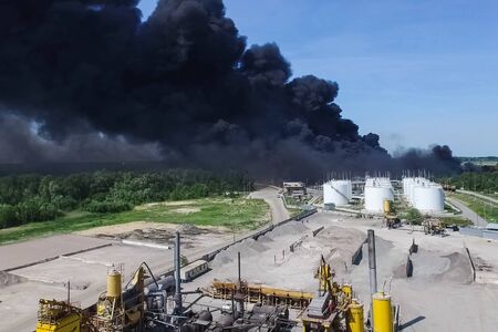 Oil storage fire. The tank farm is burning, black smoke is the combustion of hydrocarbons.の写真素材