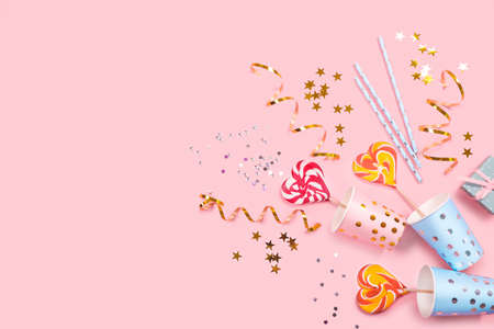 Birthday party supplies on pink background. Top view. Copy space.