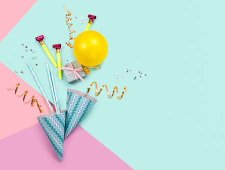 Birthday party supplies on blue and pink background. Top view. Copy space.