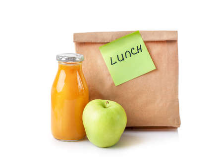 Paper bag with school lunch with juice and green apple isolated on white background.の写真素材