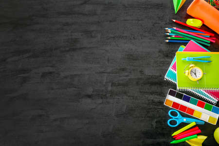 Group of school supplies on black background. Top view. Copy space. Back to school concept.