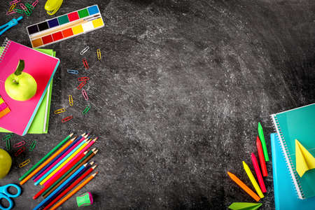 School supplies on blackboard background Top view. Copy space. Back to school concept.