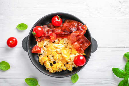 American breakfast with scrambled eggs and roasted bacon on white background. Top view.の写真素材