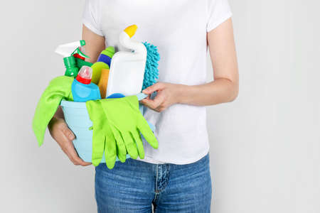 Woman holding bucket with cleaning products