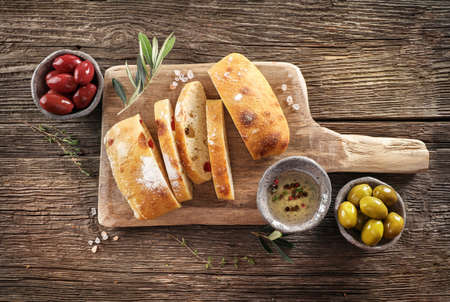 Virgin olive oil, olives and fresh bread on the table. Top viewの写真素材