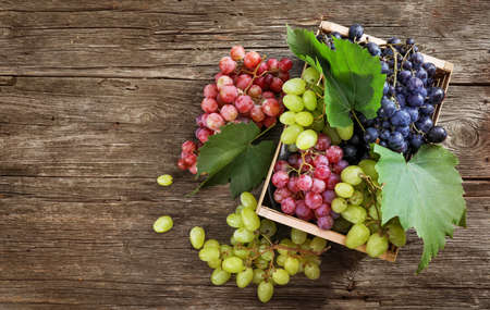 Grape in wooden box on wooden background. top view