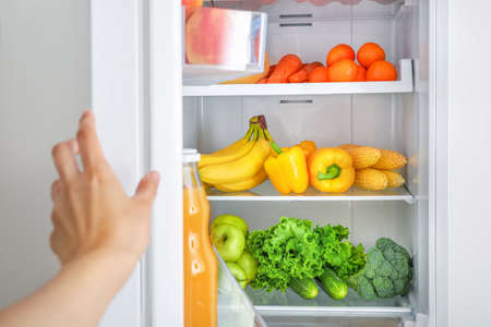 Open fridge full of vegetables and fruitsの写真素材