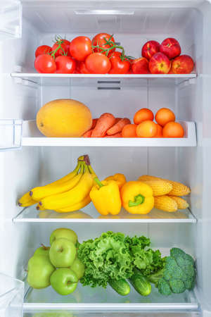 Open fridge full of vegetables and fruitsの写真素材