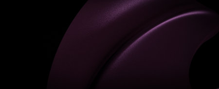 Close-up shot of a purple fabric with a smooth, flowing texture. The fabric is illuminated by light, creating a contrast between the light and dark areas.の写真素材