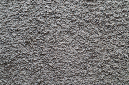 A muted gray, dense carpet fiber texture background features a uniform, soft fuzzy surface with subtle topography. Its lack of distinct focal points and shallow depth of field make it ideal for copy space.の写真素材