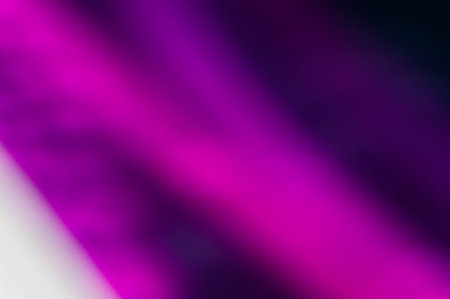 Smooth, fluid abstract gradient texture blending vivid magenta to deep purple and black. Soft focus with diffused luminous bokeh elements. Ample copy space in darker areas.の写真素材