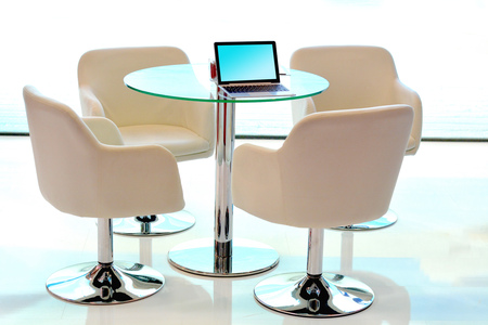 Modern conference table with chairs, laptop and white background.の写真素材