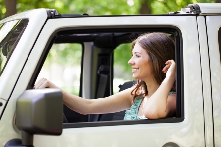 Side view of a young cheerful Caucasian woman enjoying a car ride.の写真素材