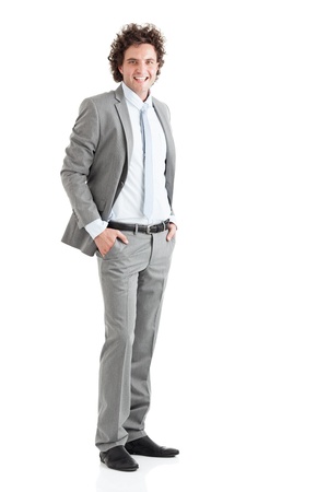 A young successful businessman with hands in pockets, isolated on white.の写真素材