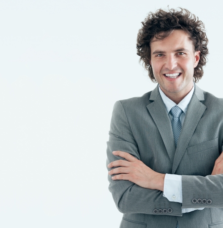 Portrait of a handsome young businessman smiling at the camera. Studio shot.の写真素材