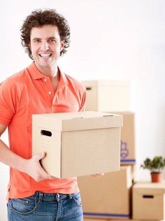 A handsome man holding a carboard box in his hands の写真素材