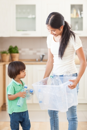 A mother teaching her child that plastic bottles should be recycled.の写真素材