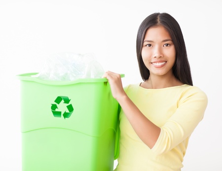 Young Asian woman with a crate full of plastic bottles for recycling.の写真素材