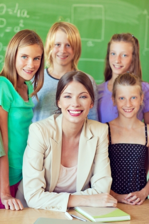 A teacher posing with her students in the classroom.の写真素材