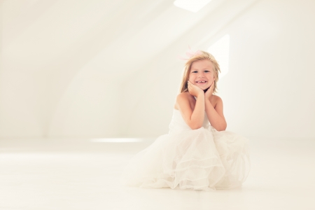 Cute smiling girl in a white dress.の写真素材