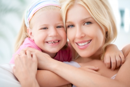 A mother and her daughter hugging and smiling.の写真素材