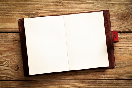 Opened personal organizer on a wooden surface.の写真素材