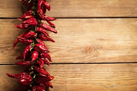Bunch of dried red chilli peppers on a wooden board.の写真素材