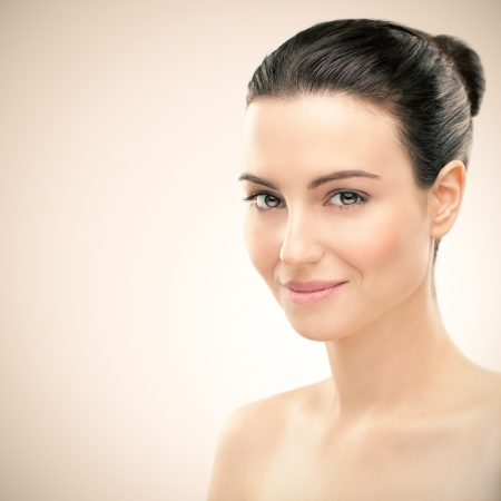 Portrait of a beautiful young brunette posing in front of a pink background.の写真素材