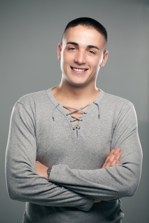 Portrait of a handsome smiling man standing with his arms crossed.の写真素材