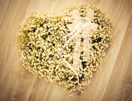 Heart-shaped wedding flower arrangement with wedding rings on it.の写真素材