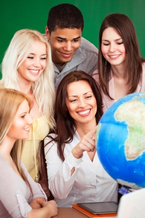 Geography teacher showing something on the globe to her students.の写真素材