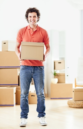A handsome man holding a carboard box in his hands.の写真素材