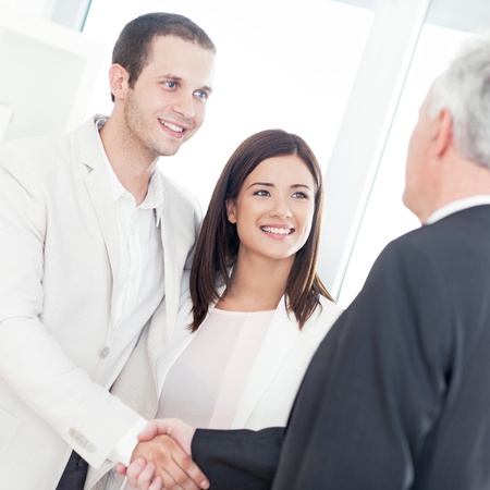 A married couple shaking hands with their financial advisor.の写真素材