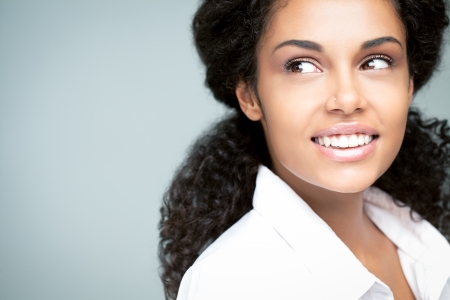 Beautiful smiling African woman posing against a gray background.の写真素材