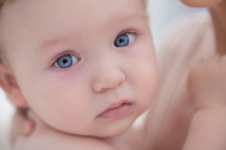 Portrait of a blue-eyed baby boy in his motherの写真素材