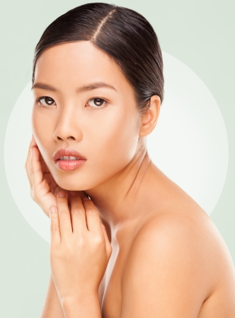 Beautiful young Asian woman gently touching her face.の写真素材