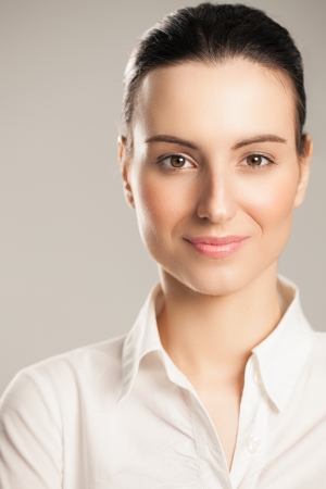 Portrait of a smiling businesswoman posing in a white shirt.の写真素材