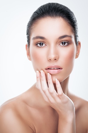 Beautiful Caucasian woman gently touching her face.の写真素材