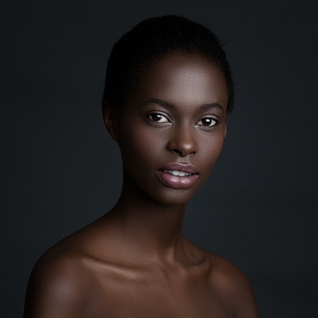 Beautiful African woman posing in front of a dark background.の写真素材