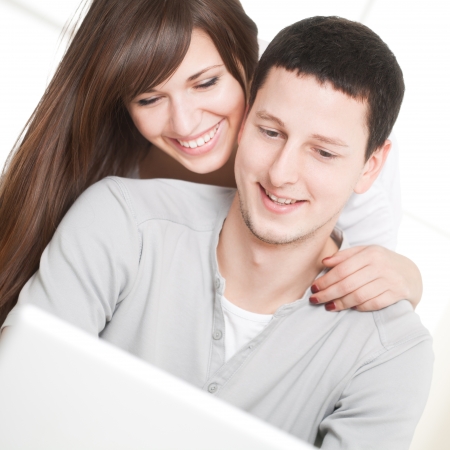 Portrait of a happy couple using laptop in the living room の写真素材