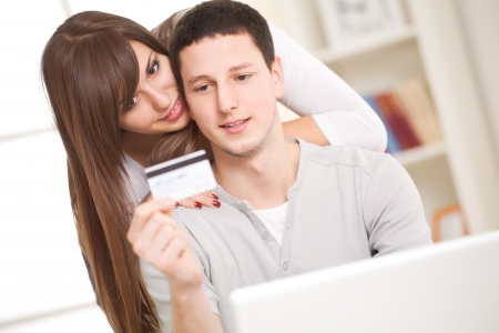 Portrait of a happy couple using laptop for banking transactions の写真素材