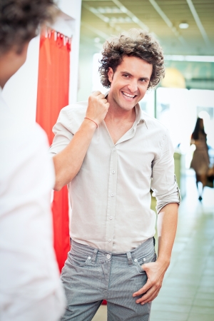 A handsome man looking at his reflection in the mirror at a boutique.の写真素材