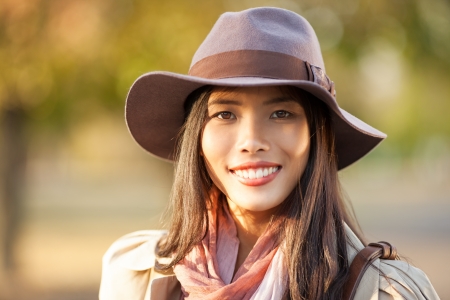 Beautiful Asian woman smiling outdoors on an autumn day.の写真素材